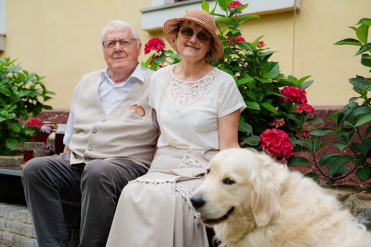 Saimnieki uz mājas kāpnēm kopā ar suni